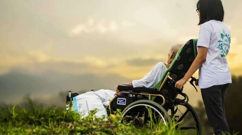AVC : photo d'un infirmière qui pousse le fauteuil d'un handicapé suite à AVC