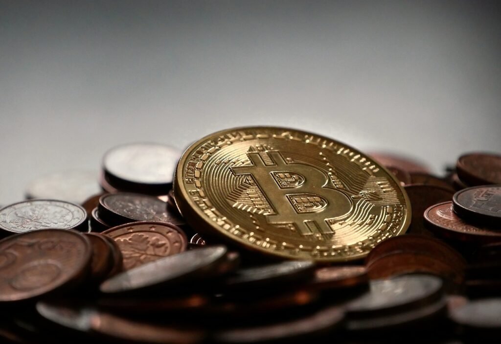 Photo d'une fausse pièce de monnaie Bitcoin sur un tas de pièces d'euro pour illustrer l'article sur l'adoption du projet Mica voté par le Parlement européen