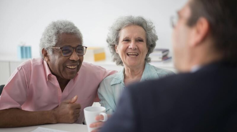 Photographie de deux retraités face à leur banquier